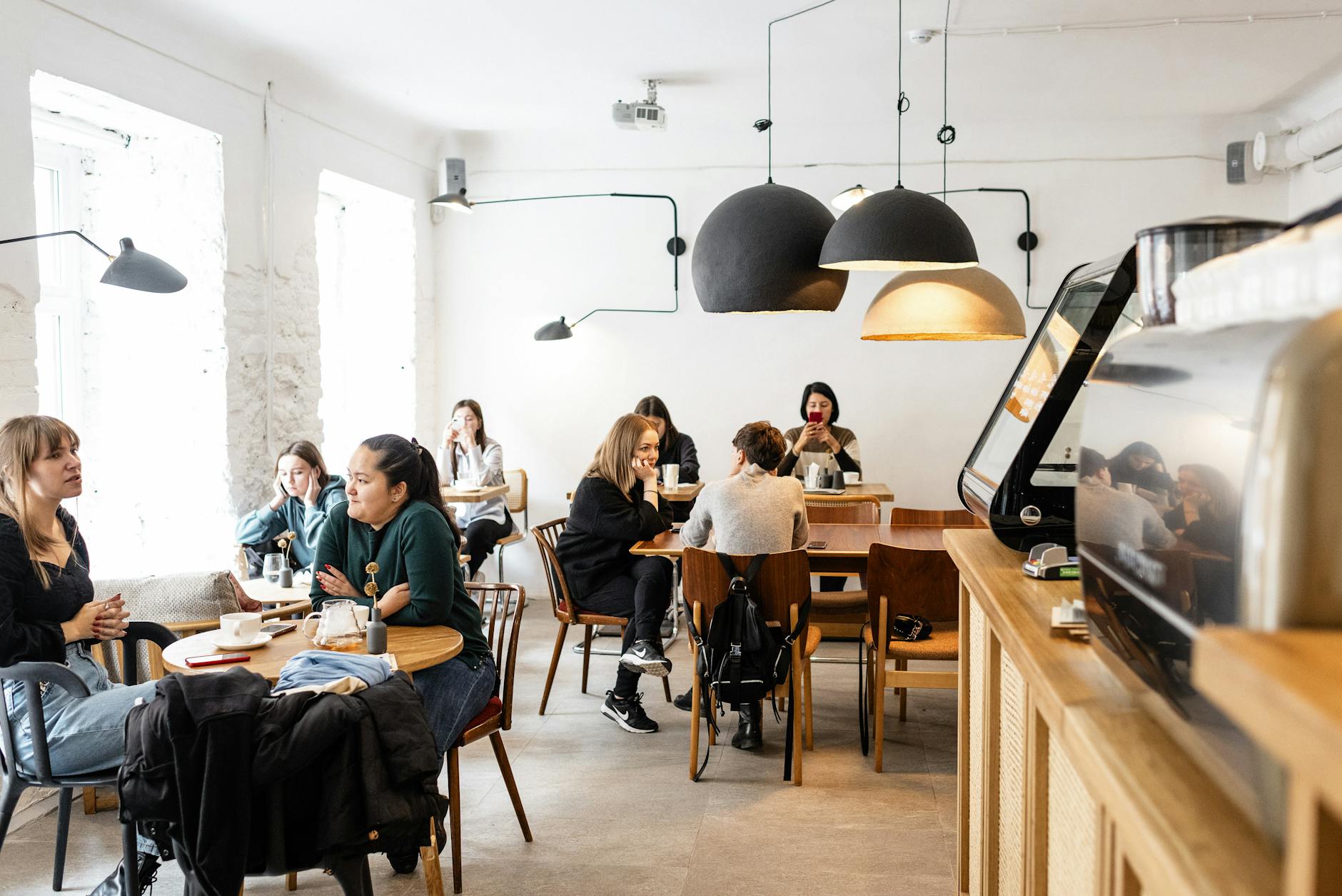 group of diverse friends sitting in modern cafe