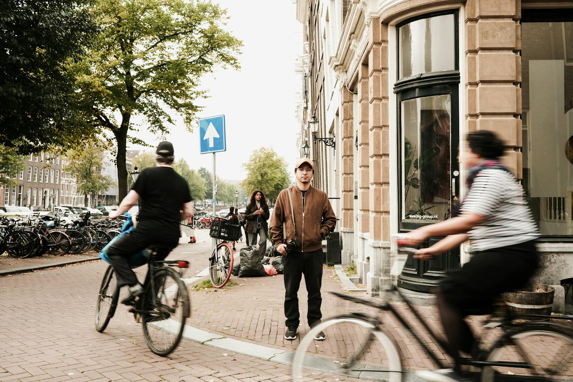 man in jacket behind people on bicycles